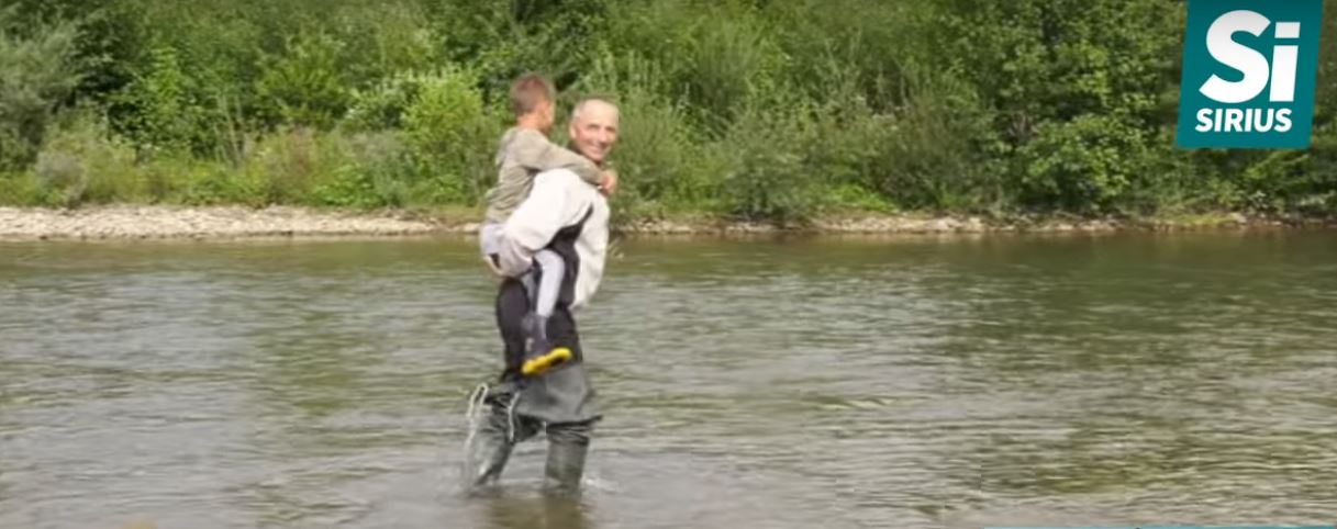 Батько несе дитину через річку - Тячівщина